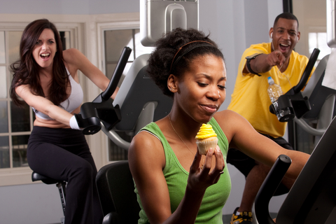 woman exercising and not losing weight eating a cupcake