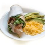 turkey avocado wrap with cheese and avocado on side