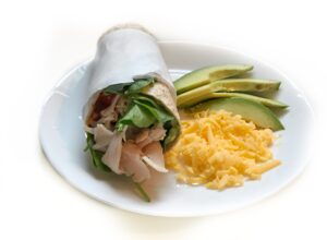 turkey avocado wrap with cheese and avocado on side