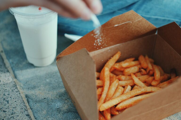 french fries with salt being added in box