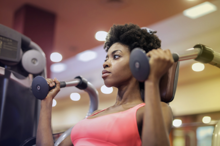 black woman exercising with a weight machine