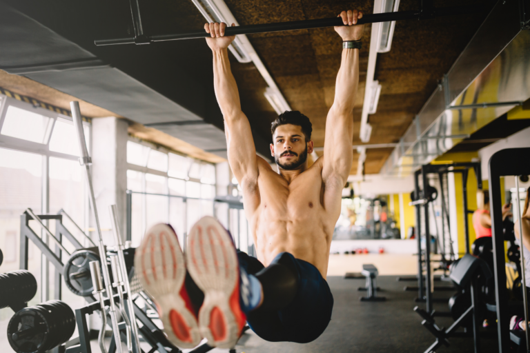 man hanging from bar at gym doing ab exercises
