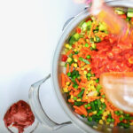 Adding tomatoes to the peruvian stew