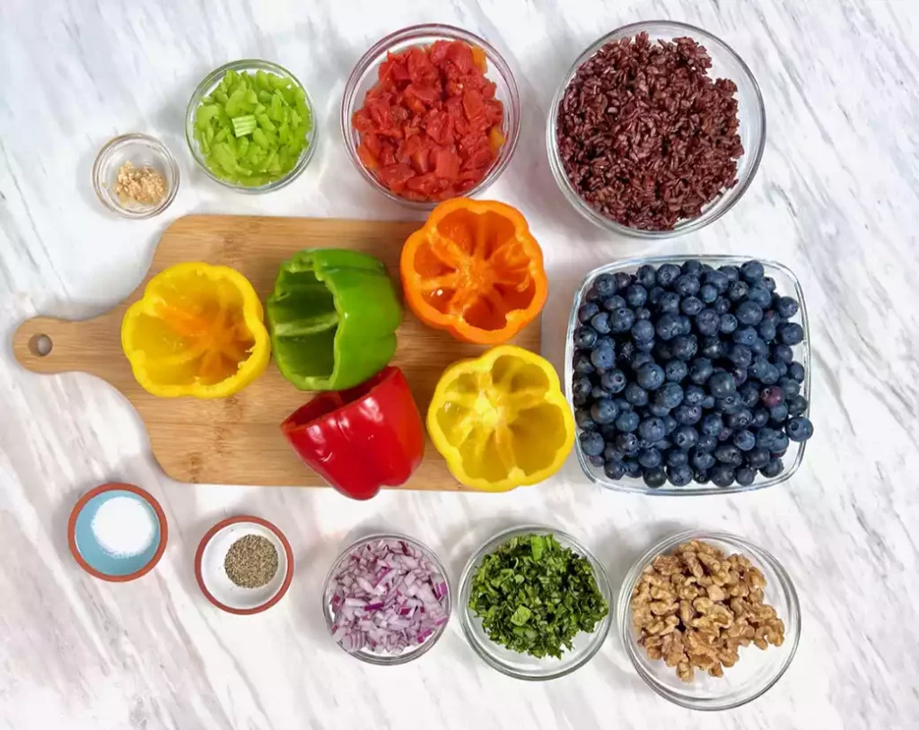 Ingredients for air fryer stuffed bell peppers with blueberries on marble counter